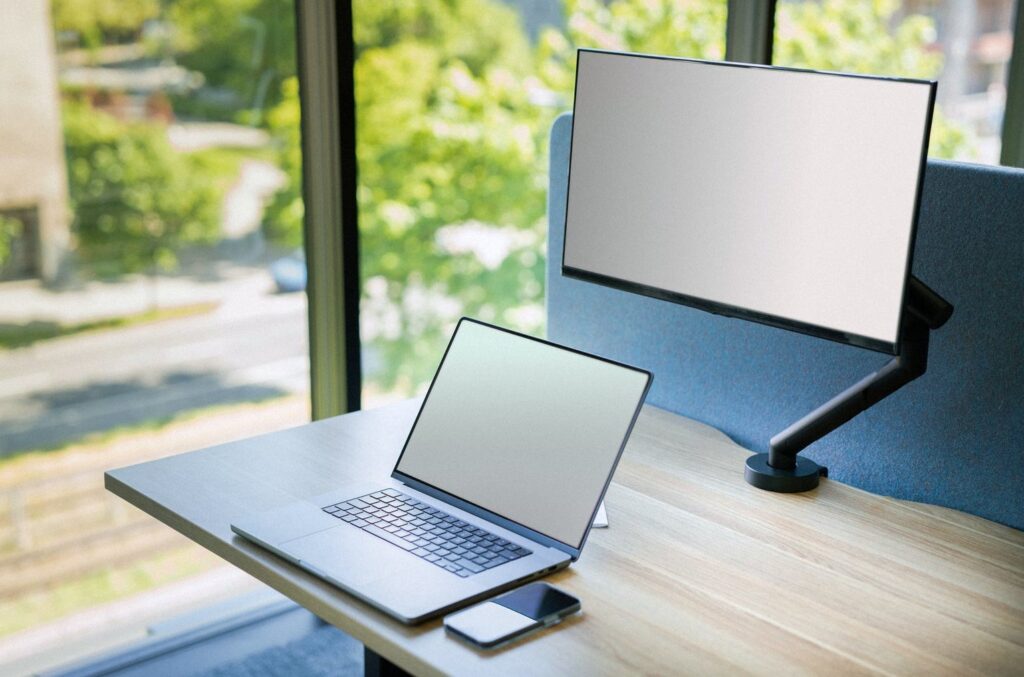 Monitor na ramieniu, górna krawędź ekranu na wysokości oczu, ujęcie z boku